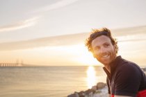 Чоловік на скелястій береговій лінії на заході сонця — стокове фото