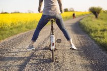 Mulher de bicicleta na estrada rural — Fotografia de Stock