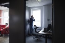 Человек разговаривает на смартфоне в офисе — стоковое фото