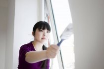 Woman painting window — Stock Photo