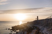 Велогонщик на скалистом побережье — стоковое фото