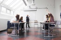 Studenti seduti a lezione con insegnante in aula — Foto stock