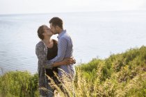Мужчина и женщина целуются на берегу моря — стоковое фото