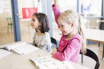 Mädchen erheben die Hand im Klassenzimmer — Stockfoto