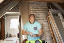 Mann arbeitet an Sanierung des alten Dachgeschosses — Stockfoto