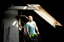 Mann im Sonnenlicht schaut durch Fenster — Stockfoto