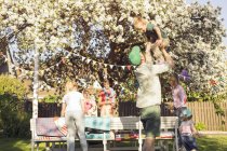 Persone con bambini al picnic in giardino con albero in fiore — Foto stock