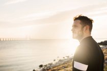 Uomo in abbigliamento sportivo guardando il mare — Foto stock