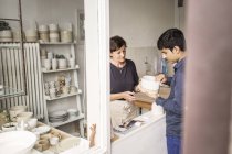 Potter showing product to customer — Stock Photo