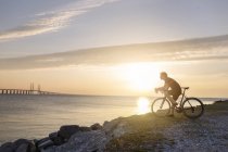 Велогонщик на скалистом побережье — стоковое фото