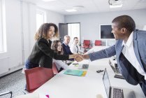 Colleagues handshaking in office — Stock Photo
