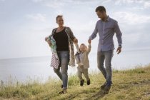 Parents with sons walking on coastline — Stock Photo