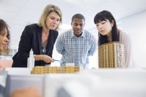 Architects looking at buildings model — Stock Photo