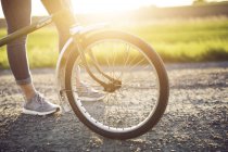 Велосипедное колесо на дороге при солнечном свете — стоковое фото