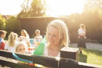 Woman and girl decorating fence at garden party — Stock Photo