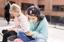 Meninas sentadas com smartphones — Fotografia de Stock
