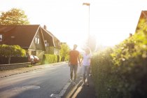 Front view of young couple walking down suburban road — Stock Photo