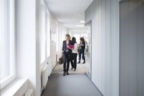 Colleagues walking through corridor — Stock Photo