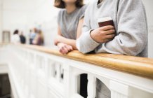 Dois estudantes em pé por trilhos na frente de armários com café — Fotografia de Stock