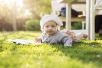 Bambina sdraiata sull'erba in giardino — Foto stock