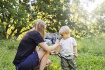 Mother spraying son (2-3) with insect repellant — Stock Photo
