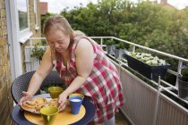 Woman with down syndrome preparing snack on balcony — Stock Photo