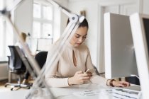 Бізнес-леді використовуючи телефон в офісі — стокове фото