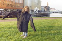 Menina sorridente (4-5) vestindo casaco de grandes dimensões — Fotografia de Stock