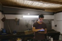 Mann benutzt digitales Tablet in Garage — Stockfoto