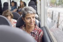 Frau blickt durch Busfenster — Stockfoto