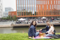 Ritratto di genitori con figlia (4-5) che si godono un picnic con concerto in sottofondo — Foto stock