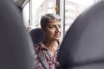 Femme regardant par la fenêtre du bus — Photo de stock