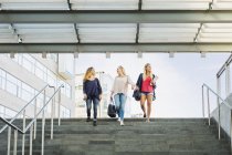 Tre giovani donne che scendono le scale — Foto stock