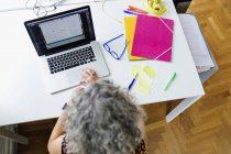 Повышенный обзор деловой женщины с помощью ноутбука в офисе — стоковое фото