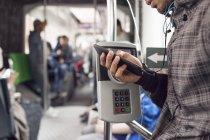 Mann benutzt Smartphone im Bus — Stockfoto