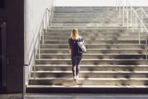 Woman walking up stairs from below — Stock Photo