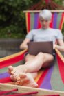 Frau benutzt Laptop tagsüber auf Hängematte — Stockfoto