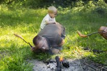 Человек с сыном (2-3) разжигает огонь в лагере — стоковое фото