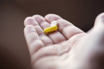 Close-up de mão segurando pílulas — Fotografia de Stock