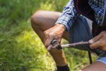 Bâton d'affûtage homme en forêt pendant la journée — Photo de stock