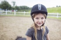 Portrait of girl (4-5) in equestrian helmet — Stock Photo