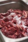 Куски сырой свинины с солью — стоковое фото