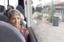 Frau blickt durch Busfenster — Stockfoto