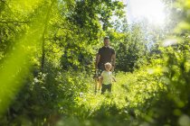 Father and son (2-3) in forest during daytime — Stock Photo