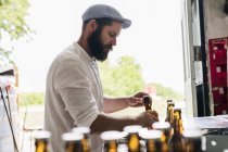 Brewery worker preparing beer bottles — Stock Photo