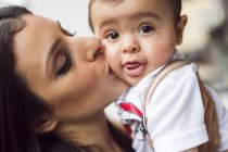 Mother kissing baby son (6-11 months) — Stock Photo