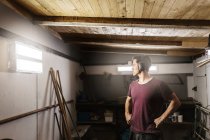 Uomo che indossa paraorecchie in garage — Foto stock