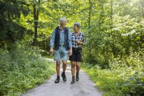 Casal caminhando na floresta durante o dia — Fotografia de Stock
