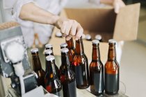 Работник пивоварни готовит пивные бутылки — стоковое фото