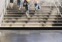 Four people walking up stairs — Stock Photo